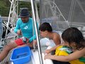 Leighton instructs the young crew in fish cleaning